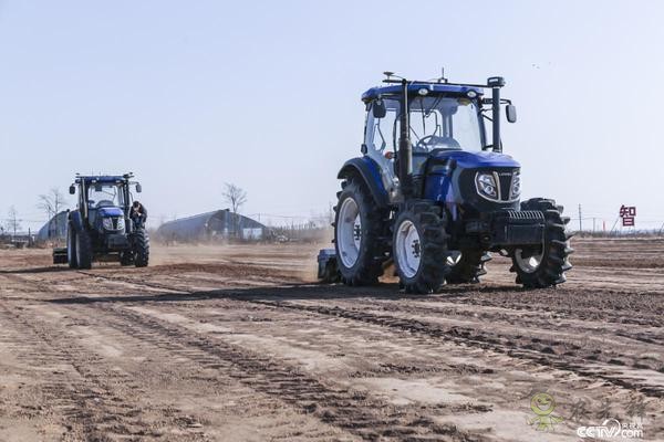 无人驾驶拖拉机牵引旋耕机对地块进行耕整作业
